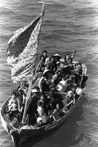 35 Vietnamese refugees wait to be taken aboard the amphibious command ship USS BLUE RIDGE (LCC-19). They are being rescued from a 35 foot fishing boat 350 miles northeast of Cam Ranh Bay, Vietnam, after spending eight days at sea. Photo by Phil Eggman