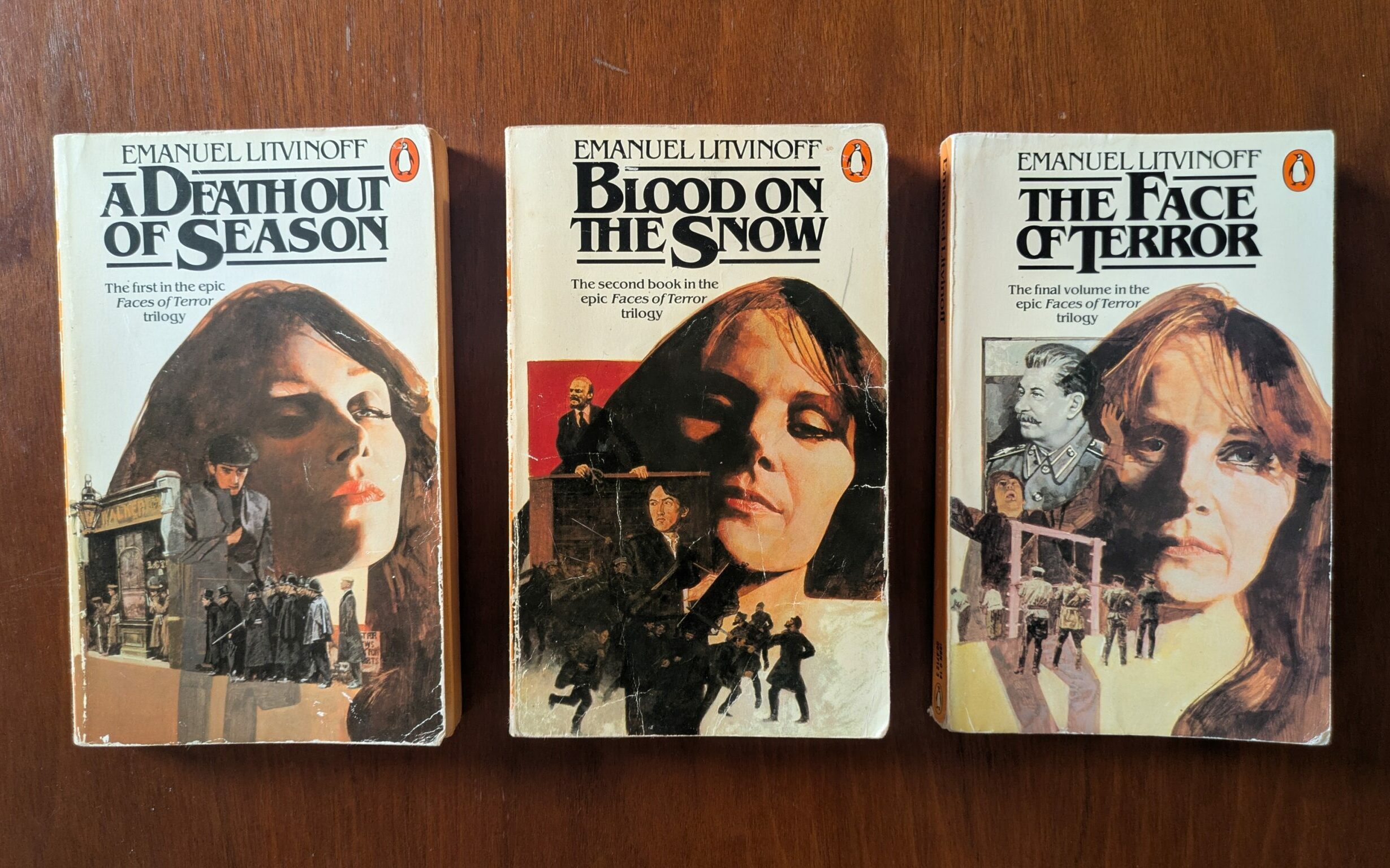A photograph of three books laying side by side on a wooden table. Each book cover has the author's name, Emanuel Litvinoff, on the top, with the book title in bold underneath, and large illustrations.